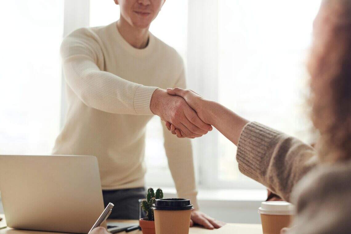 Serrage de main entre deux personnes suite à un partenariat